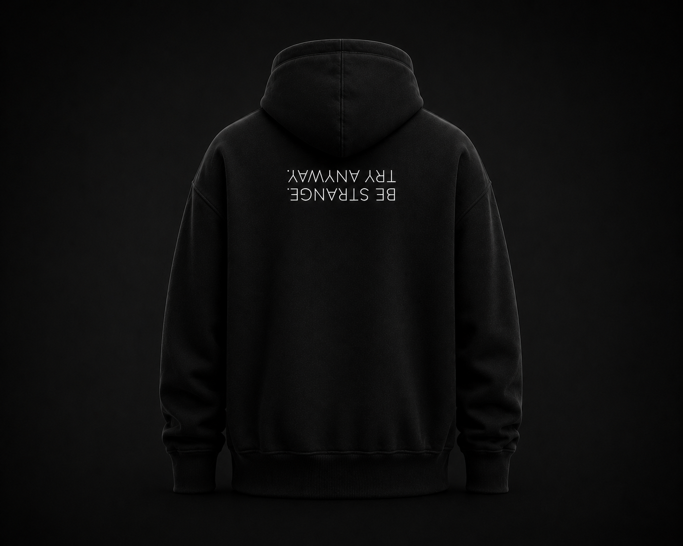 Back view of the black LILMATEEN hoodie with the upside-down Be Strange Try Anyway message